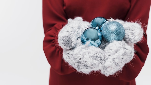 Guantes de invierno de primer plano y bolas de navidad