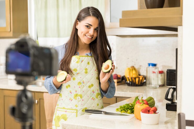 Foto gratuito guapa joven morena dando algunos consejos de cocina y consejos para su video blog en casa