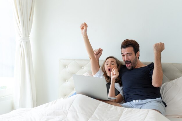 El guapo esposo y la hermosa esposa se sienten muy bien cuando el fútbol que vitorean es el campeón ganador en la habitación.