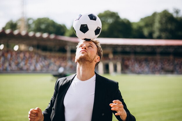 Guapo futbolista en el estadio en traje de negocios