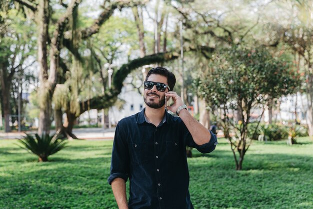 Guapo hablando por teléfono en el parque