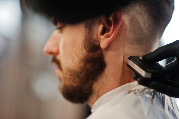 Foto gratuita guapo hombre barbudo en la barbería peluquero en el trabajo cerrar nuca