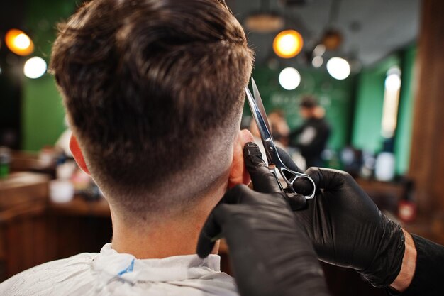 Guapo hombre barbudo en la barbería peluquero en el trabajo