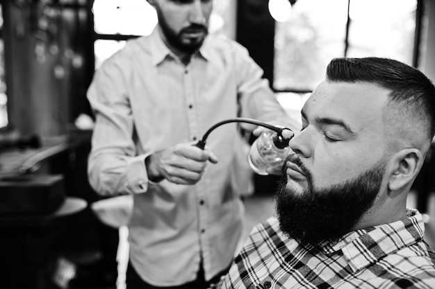 Guapo hombre barbudo en la barbería peluquero en el trabajo