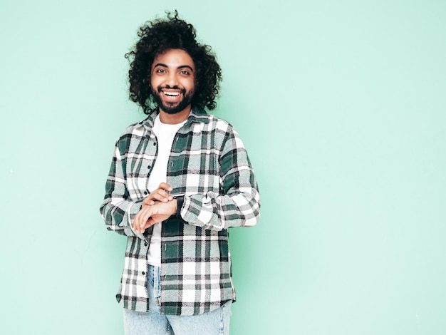 Guapo hombre hipster sonriente posando en el estudio