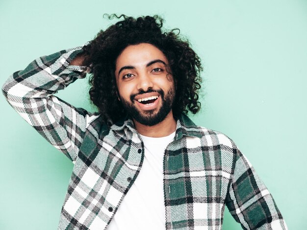 Guapo hombre hipster sonriente posando en el estudio