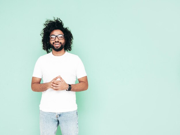 Guapo hombre hipster sonriente posando en el estudio