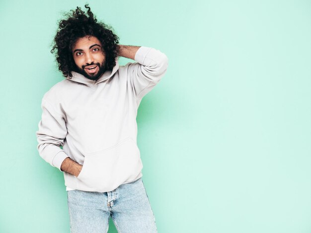 Guapo hombre hipster sonriente posando en el estudio