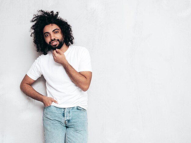 Guapo hombre hipster sonriente posando en el estudio