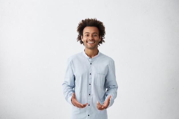 Foto gratuita guapo joven afroamericano vistiendo camisa larga luz sonriendo