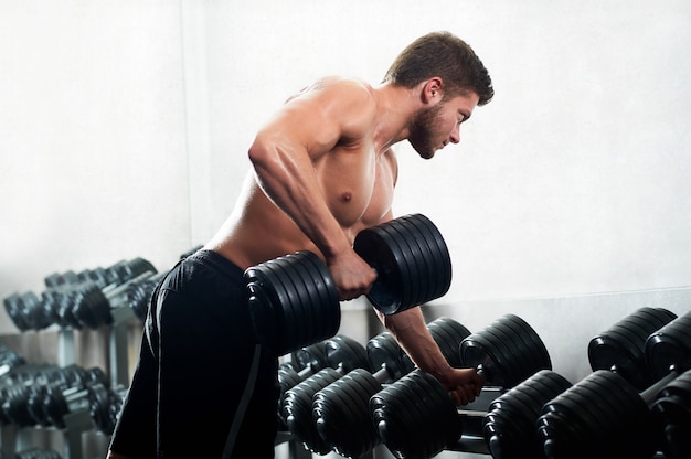 Guapo joven atleta trabajando en el gimnasio