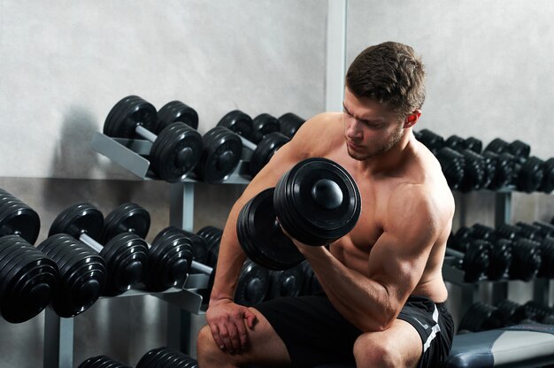 Guapo joven atleta trabajando en el gimnasio