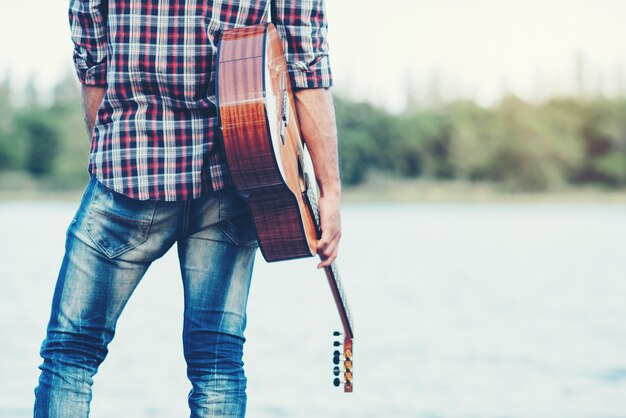 guapo musico adulto tocando guitarra acustica