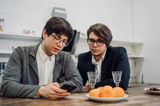 Guapos empresarios hablando en la cocina de la oficina