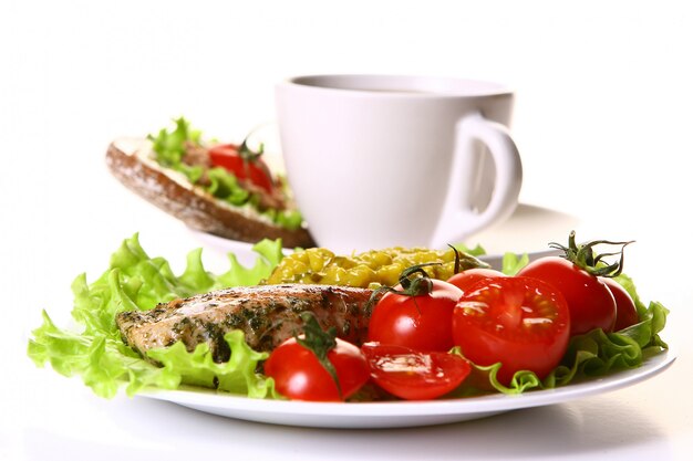 Guarnición de comida con filete y verduras y café.