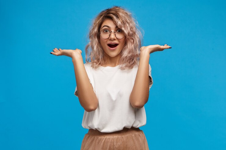 Foto gratuito guau. divertida y fascinada joven europea con cabello voluminoso desordenado gesticulando emocionalmente y manteniendo la boca bien abierta, sin creer en tus palabras