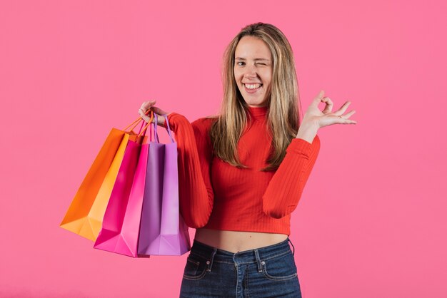 Guiño de niña sosteniendo bolsas de compras