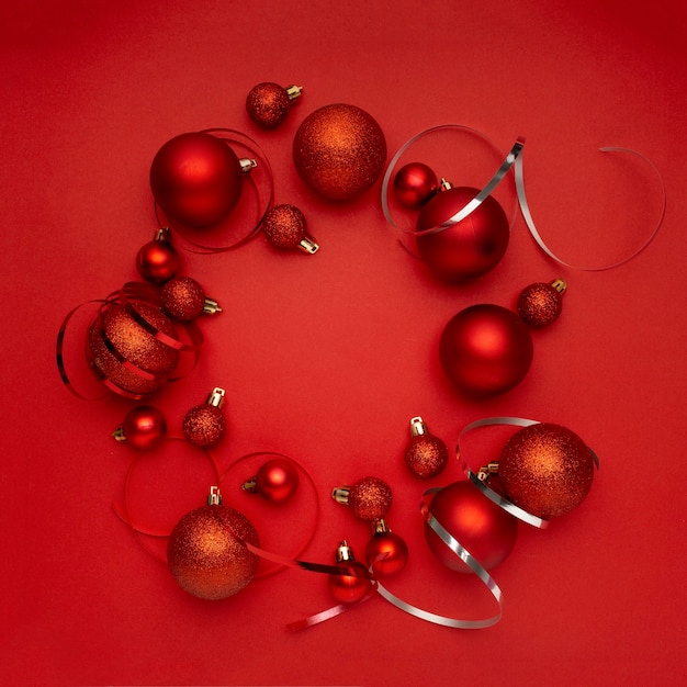 Foto gratuita guirnalda de bolas de navidad rojas en mesa roja