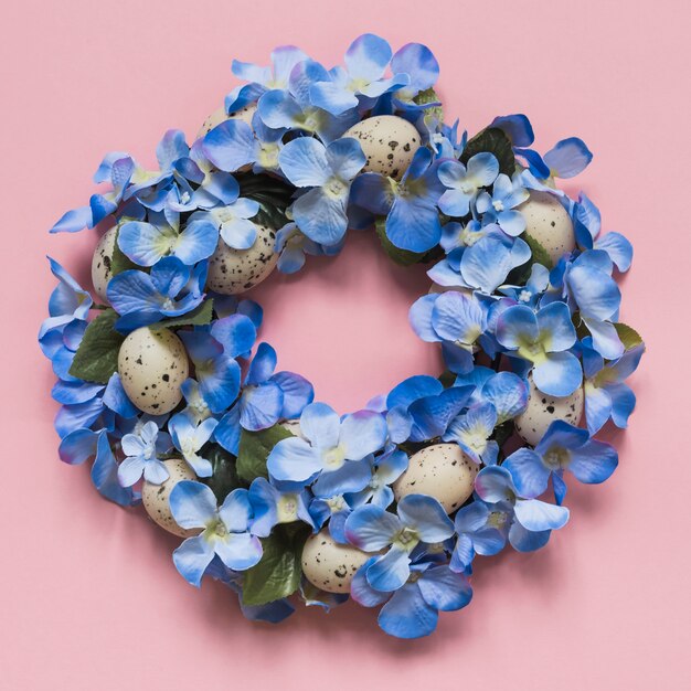 Guirnalda hecha de flores azules y huevos.