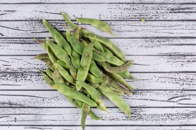 Guisantes en una mesa de madera gris