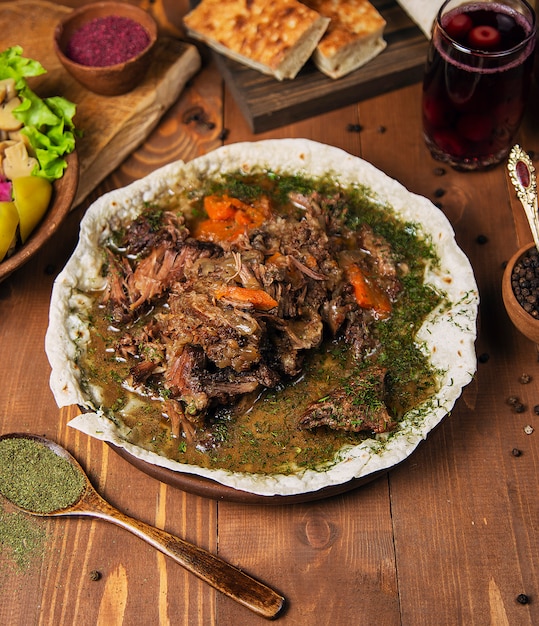 Guiso de carne, turshu govurma con cebolla, hierbas verdes, zanahorias en salsa de caldo.