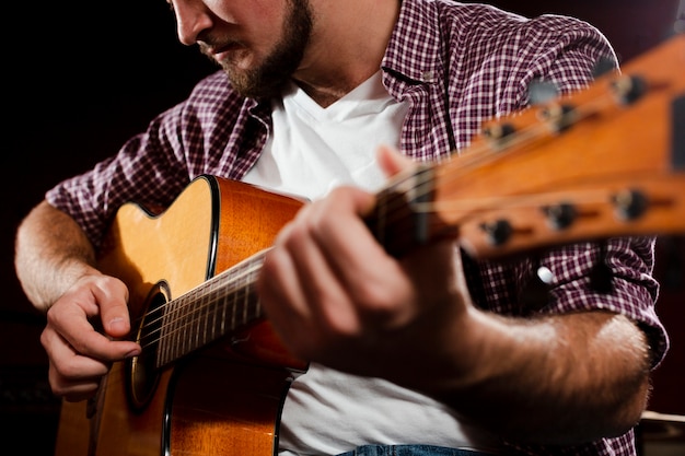 Guitarra acústica borrosa y chico tocando close-up