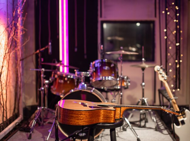 Guitarra acústica en el estudio de grabación. Sala para ensayos de músicos.