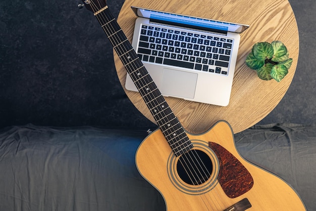 Foto gratuita guitarra acústica y portátil en una mesa de madera