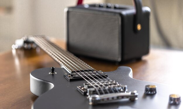 Foto gratuita guitarra eléctrica negra y altavoz en una mesa de madera