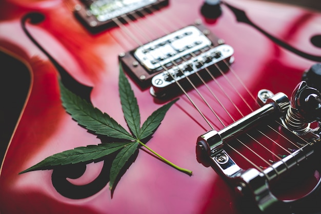 Guitarra eléctrica roja con hoja de cannabis