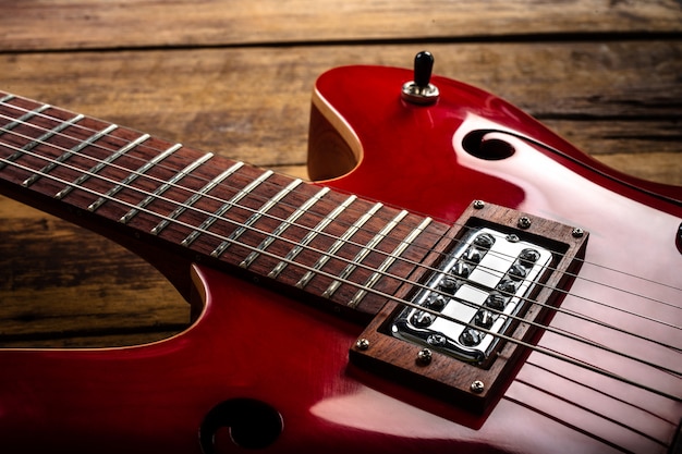 Guitarra eléctrica roja sobre suelo de madera