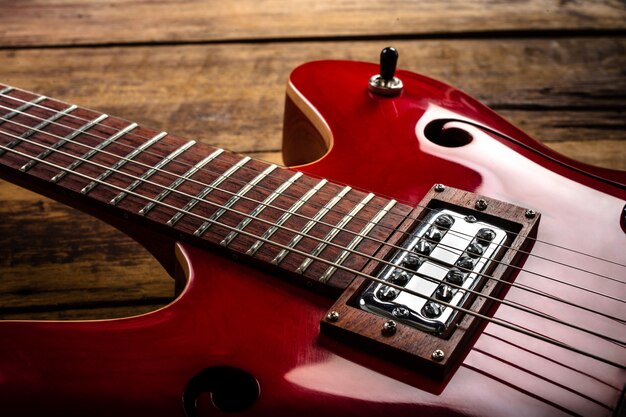 Guitarra eléctrica roja sobre suelo de madera