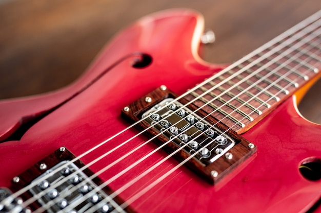 Guitarra eléctrica roja sobre suelo de madera