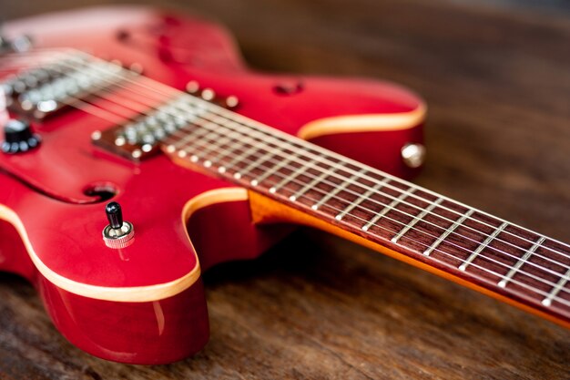 Guitarra eléctrica roja sobre suelo de madera