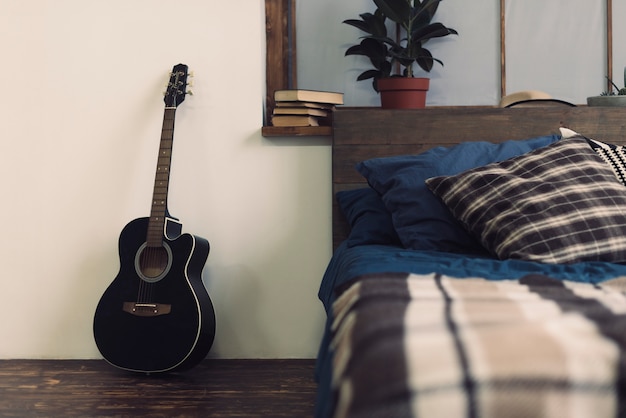 Foto gratuita guitarra a lado de cama