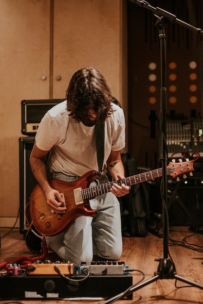 Guitarrista de la banda de rock realizando repetición en estudio de grabación