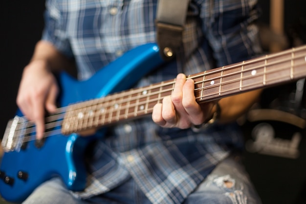 Guitarrista con guitarra azul en silla