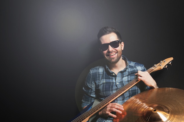 Guitarrista sonriente sobre fondo negro