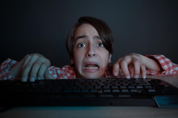 Foto gratuita le gusta jugar y ganar videojuegos. en la luz azul de la pantalla, los niños emocionales juegan juegos de computadora en línea.