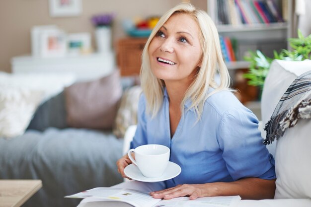 Le gusta relajarse con el periódico y el café.