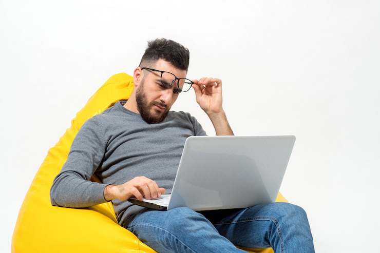 Foto gratuito guy está mirando de cerca en la computadora portátil