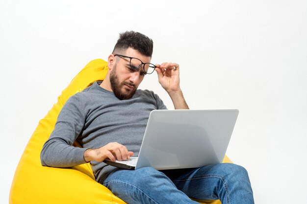 Guy está mirando de cerca en la computadora portátil