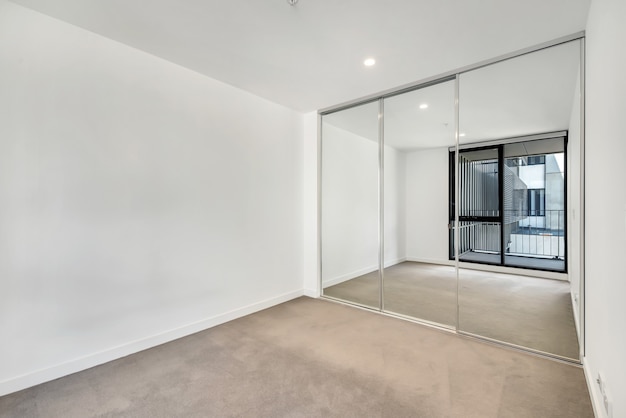 Foto gratuita habitación vacía con el reflejo de las ventanas en el armario con espejos