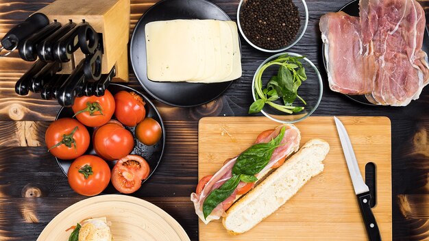 Hacer sándwiches en la cocina sobre tabla de madera