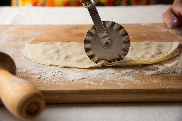 Haciendo gutab sobre tabla de madera. Cocina nacional de Azerbaiyán.