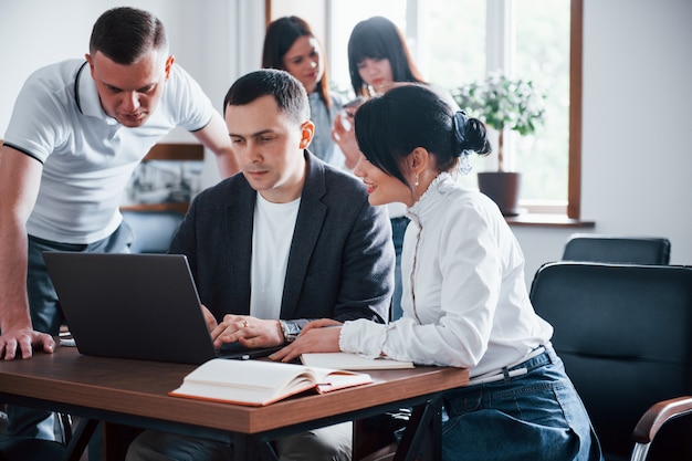 Foto gratuita haciéndolo juntos. empresarios y gerente trabajando en su nuevo proyecto en el aula