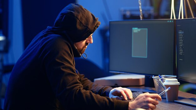 Hacker en un almacén abandonado hablando por teléfono con su compañero
