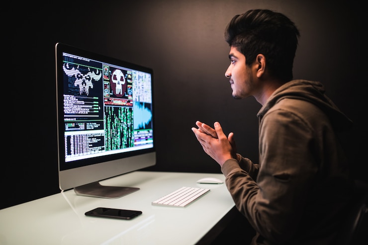 Foto gratuito hacker indio usando computadoras para robar datos en el escritorio oscuro