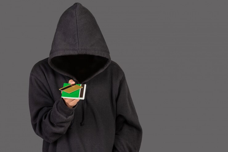 Foto gratuito el hacker lleva una tarjeta de crédito de oro y un libro bancario.