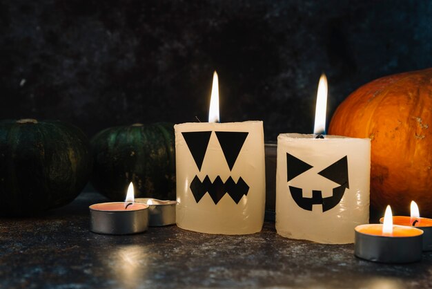 Halloween velas ardientes de pie rodeado de calabazas